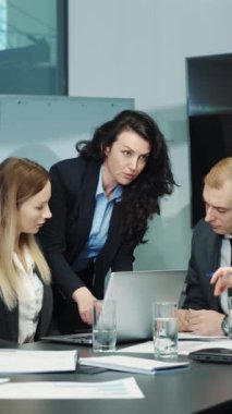 Dikey ekran: Resmi olarak çalışan bir grup iş adamı ofiste birlikte çalışıyor, dizüstü bilgisayardaki raporlara bakıyor, projeyi tartışıyor ve fikirleri paylaşıyorlar. Yöneticilerden oluşan bir ekip strateji planlıyor