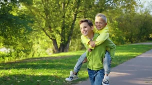 Gelukkige Kind Genieten Rijden Hun Broers Buiten Een Lachende Tiener — Stockvideo