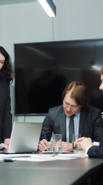 Dikey ekran: Üst düzey yöneticiler sözleşme imzalıyor ve ofiste el sıkışıyor, toplantı üyeleri el çırpıyor. İş ortakları anlaşma yapıyor. İşbirliği kavramı
