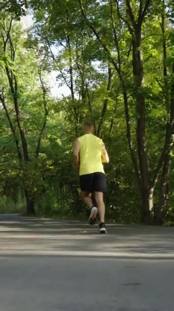Vertical Screen Slow Motion Jogger Wearing Shorts Top Running Asphalt — Stock Video
