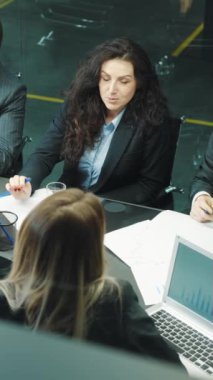 Dikey ekran: Yukarıdan bakıldığında, bir grup iş adamı ofiste toplanıyor. Ortaklar fikir paylaşımı ve planlama stratejisi. İş kavramı