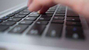 Laptop klavyesinde yazı yazan aşırı yakın plan parmaklar, seçici odaklanma. Ark ofis çalışanını ya da metin yazarını iş başında vurdu. İş kavramı