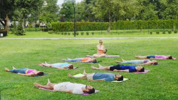 Yoga Group Relaxes Savasana Ενώ Γυναίκα Παίζει Songing Bowls Δημιουργώντας — Αρχείο Βίντεο