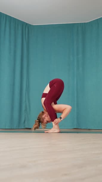 Vrouwelijke Yoga Adept Bereikt Een Ingewikkelde Armbalans Sierlijk Verheffende Benen — Stockvideo