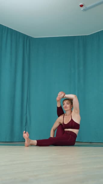 专家瑜珈手在Namaste上一腿伸一腿 另一腿弯一弯 进行着坐姿扭转 体现了先进的灵活性和集中精神 — 图库视频影像