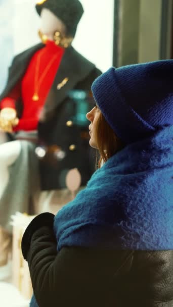 青いニットの帽子と毛皮の襟の女性は マネキンに長く目を向け 彼女のウィスティックな表情は 達成不可能な冬のファッションのための年を反映しています 最新の冬のファッショントレンド 季節スタイルのエッセンス — ストック動画