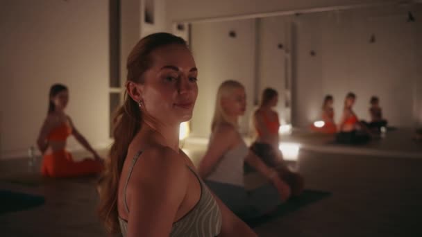 在灯光柔和的带反射镜墙的画室里练习瑜伽的女性 以安静为重点摆出坐姿 健康与团体健身概念 — 图库视频影像