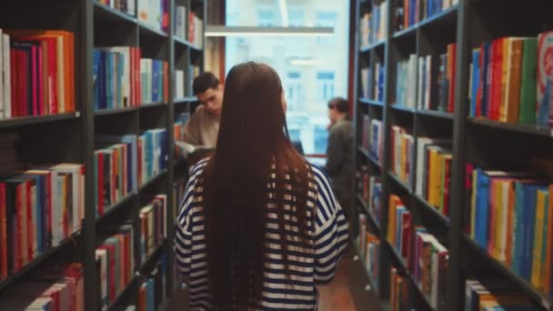 Estudiantes Navegando Libros Pasillo Biblioteca Universitaria Con Una Lectura Otra — Vídeo de stock