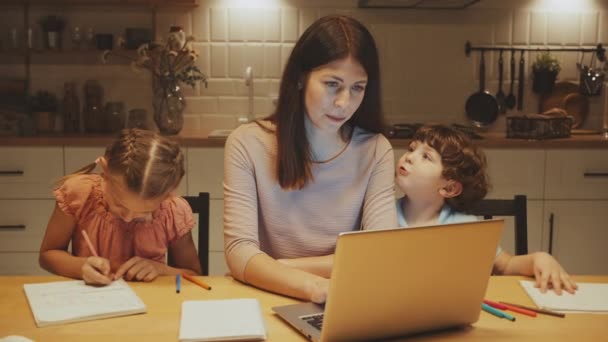 Madre Multitarea Con Portátil Mientras Sus Hijos Hacen Tarea Escena — Vídeo de stock