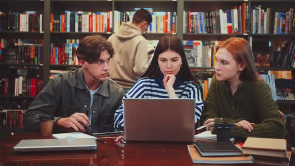 Три Студенти Єдналися Груповій Навчальній Сесії Бібліотеці Ноутбуком Книгами Столі — стокове відео