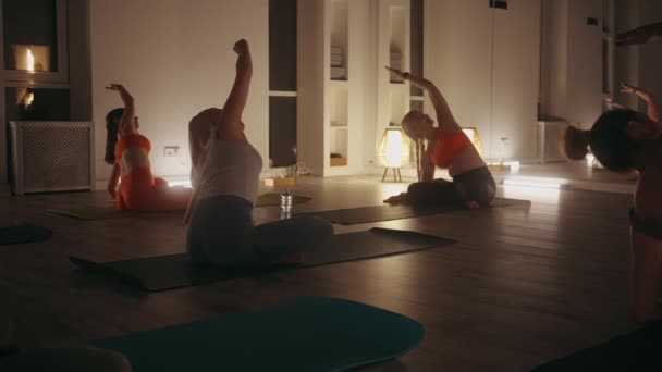 练习者在瑜伽课上找到了平衡和宁静 他们的姿势与灯光昏暗的工作室的宁静氛围相协调 — 图库视频影像