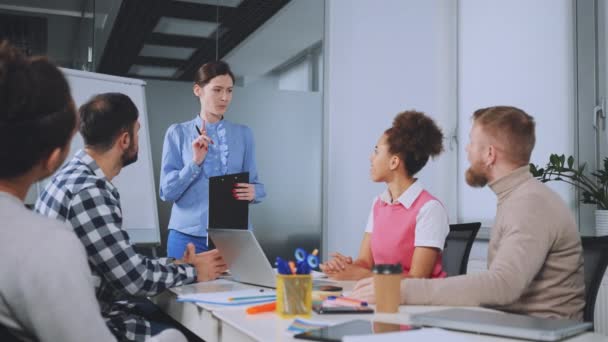 stock video Team gives round of applause to colleague who has just delivered presentation, acknowledging her efforts and success. Positive office environment fosters encouragement and support among coworkers