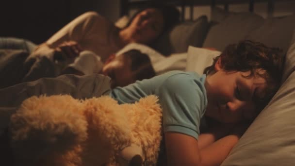 잠옷을 소년은 침대에서 불안하게 베어가 누워있는 고군분투 어머니는 사랑스럽게 그녀의 — 비디오