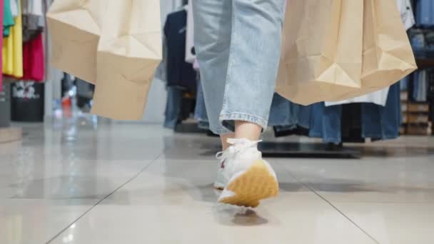 Zbliżenie Nogi Shopper Spacery Spinning Sklepie Odzieżowym Trzymając Brązowe Papierowe — Wideo stockowe