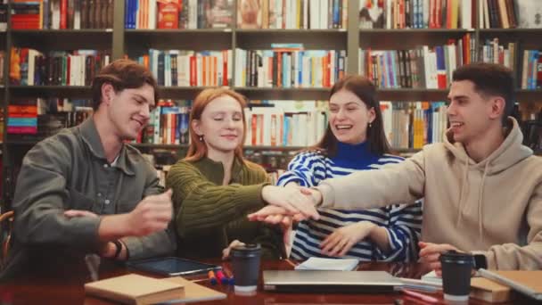 Quatre Étudiants Jubilants Table Bibliothèque Unissent Leurs Mains Dans Geste — Video