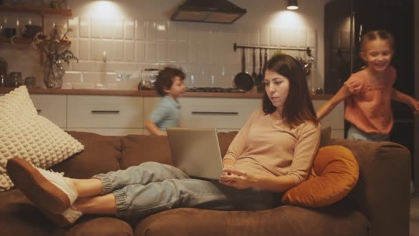 Mother Working Laptop Cozy Home Setting Skillfully Multitasking Her Kids — Stock Video