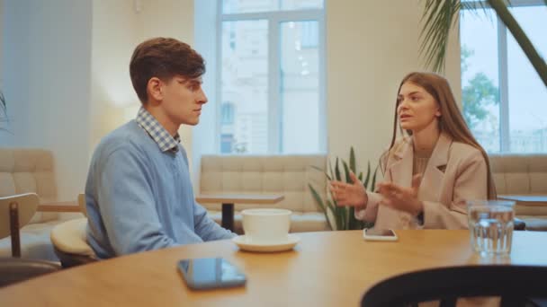 Mujer Joven Gesticula Durante Conversación Con Hombre Cafetería Tanto Busca — Vídeos de Stock