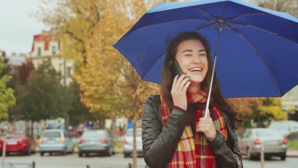 우산으로 스카프와 재킷을 여자는 꿈꾸는 거리에 대화를 즐긴다 배경에 — 비디오