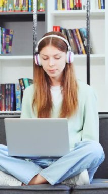 Dikey: Kulaklıklı genç kız kütüphanede dizüstü bilgisayarında yazı yazarken neşeli şarkılar dinliyor ve mırıldanıyordu. Kanepenin üzerinde Lotus pozisyonunda oturan, dizüstü bilgisayarda çalışan tatlı bir kadın. Eğitim kavramı