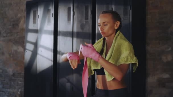 Sportowa Kobieta Metodycznie Owija Ręce Przygotowanie Boksu Tle Szafek Gimnastycznych — Wideo stockowe
