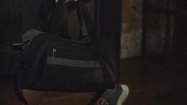 Spor çantası taşıyan kadın sporcu soyunma odasında antrenman yapmaya hazır.