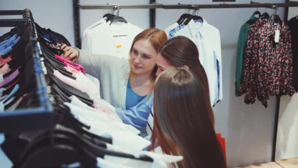 Три Жінки Переглядають Різнокольорові Стелажі Одягу Модному Магазині Насолоджуючись Часом — стокове відео