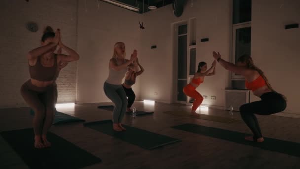 一组妇女参加瑜伽课 在灯光柔和的演播室里表演复杂的姿势 专注于集中 平衡和宁静的练习环境 — 图库视频影像