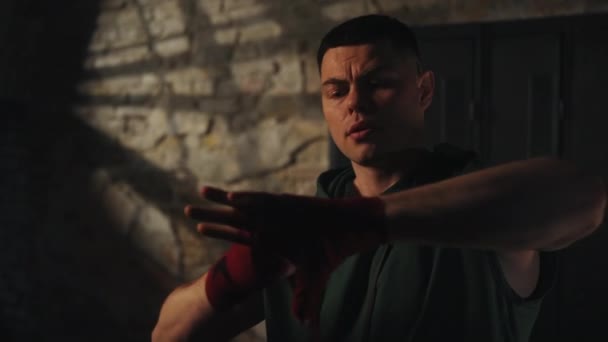 Boxeador Masculino Enfocado Envolviendo Sus Manos Con Envolturas Boxeo Rojo — Vídeo de stock