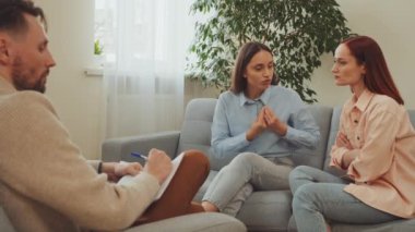 Psikolog, sakin terapi odasında derin ve anlamlı konuşmaları kolaylaştırmak için iki kadın müşteriyle danışmanlık seansı düzenliyor. Anlayış ve çözünürlüğe yönelik diyalog hızlandırılıyor