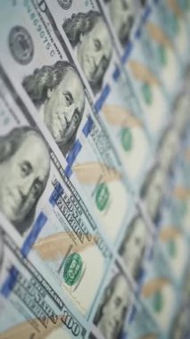Dikey ekran: 100 dolarlık banknotların Dolly çekimi düzgün bir şekilde Benjamin Franklin 'in yüzüne odaklanıyor. Kamera Amerikan para biriminin yanında hareket ediyor. Maliye ve para ödemesi kavramı