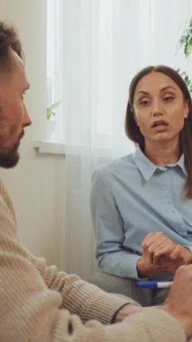 Dikey ekran: Terapi seansına katılan kadın hasta dikkatli ve dinleyici. Ruh sağlığı desteği ve profesyonel danışmanlık hizmetleri kavramı