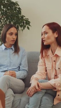 Dikey ekran: Kadın çift terapi seansı sırasında koltukta oturur, hem ciddi görünürler hem de terapi sürecinde olurlar, profesyonel bir danışmanın duygusal açıklığı...