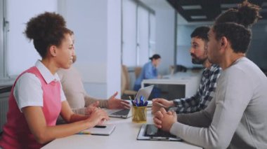 Ofis toplantısında iş arkadaşları el sıkışıyor. Başarılı iş ortaklığı ve takım çalışması kavramı. Profesyoneller arasında olumlu etkileşim ve karşılıklı saygı. Anlaşma ve işbirliği sağlandı