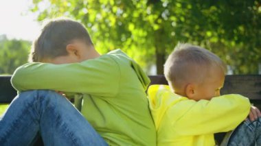İki kardeş parkta bir bankta oturuyor, birbirlerine dönüp dizlerine sarılıyorlar. İkisi de üzgün ve incinmiş görünüyor. Aile çatışması ve duygular kavramı