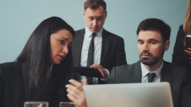 İş adamları toplantıda proje detaylarını tartışıyor. Takım üyeleri dizüstü bilgisayara ve tablete odaklandı. Takım çalışması, işbirliği ve proje yönetimi kavramı