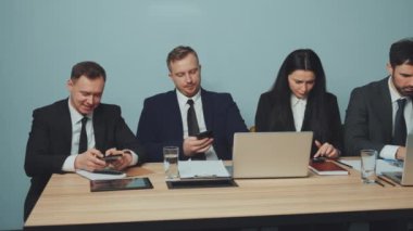 Mola sırasında masada oturan bir grup iş adamı, her biri akıllı telefonlarına dalmıştı. Gezici bağımlılık yaygınlığı ve şirket ortamında dikkat dağıtma. İş molası kavramı