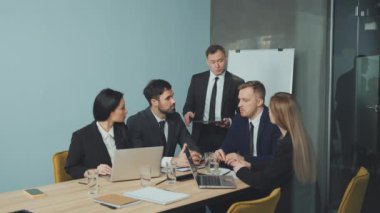Resmi giyinmiş bir grup iş adamı konferans masasının etrafında ciddi bir tartışma içerisindeler. Şirket ortamında takım çalışması ve işbirliği. Şirket toplantısı kavramı