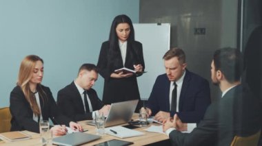 İş adamları strateji tartışıyor, önemli meseleler ve gelecekteki projeler için strateji oluşturuyorlar. Lider toplantı sırasında talimat veriyor. Takım çalışması, işbirliği ve proje yönetimi kavramı