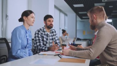 Muhtelif profesyonellerden oluşan bir grup ofiste başarılı bir toplantının ardından el sıkışıyor ve gülümsüyor, anlaşma ve işbirliğini sembolize ediyor. Ortaklık ve karşılıklı saygı kavramı