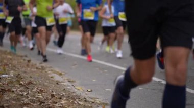 Bir grup koşucu asfalt yolda maratona katılıyor. Uzun mesafe koşusunda dayanıklılık, zindelik ve rekabet ruhu kavramı