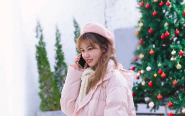 Sıcak kışta elinde telefon tutan kız.