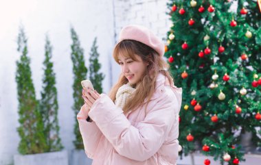 Sıcak kışta elinde telefon tutan kız.