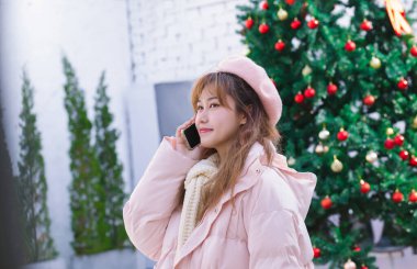 Sıcak kışta elinde telefon tutan kız.