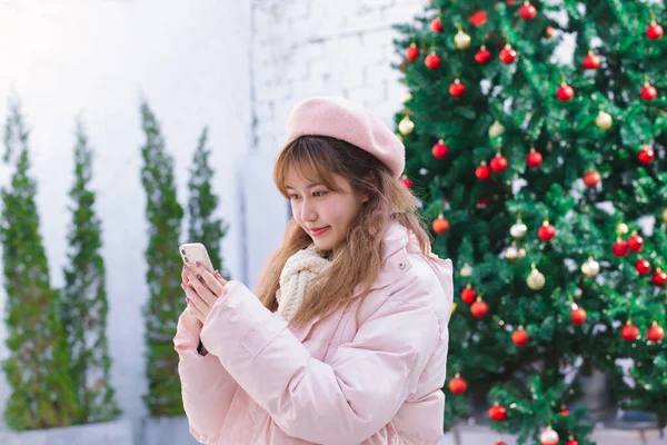 Sıcak kışta elinde telefon tutan kız.
