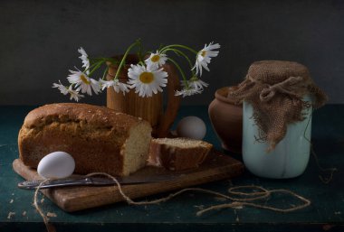 Taze bahar çiçekleri ve meyveli bir bardak süt.