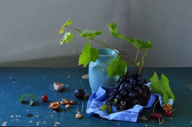 Koyu arkaplanda yaprakları olan taze organik üzümler.