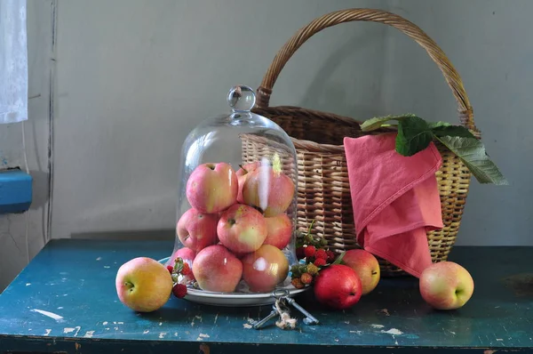 红色的苹果和成熟的桃子放在蓝色背景的木制桌子上 — 图库照片