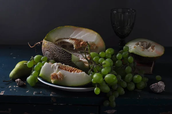 stock image still life with grapes and nuts on a wooden board