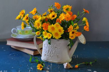 Çiçek demeti ve kır çiçekleri koyu arkaplanda, masada.