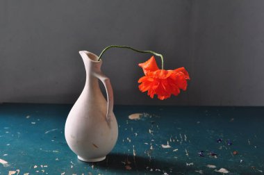 Kırmızı lale çiçekleri ve ahşap masada vazosu olan sakin bir hayat.